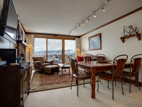 Gather around your dining table with mountain views as your backdrop, or sink into the cozy living area by the fireplace. This welcoming space blends warmth and comfort for unforgettable evenings.