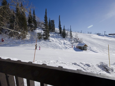 The property sits at the base of ski slopes, providing direct access to winter sports and scenic mountain terrain surrounded by evergreen trees.