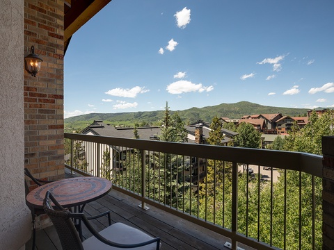 The property is located in a scenic residential area surrounded by rolling green mountains and neighboring homes, offering an appealing mountain backdrop upon arrival.
