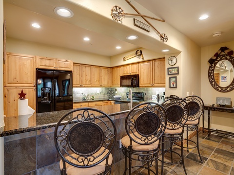 Gather around your fully equipped kitchen island with elegant bar seating—perfect for sharing meals and making memories with your travel companions in this inviting space.
