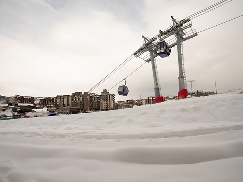 A ski resort gondola system overlooks snow-covered slopes and the surrounding mountain village, offering easy access to winter adventures in the area.