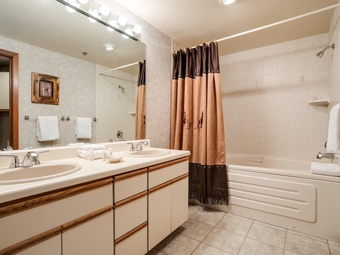 Your spacious bathroom features a dual-sink vanity, a full tub with shower, and plush towels—designed for comfort and convenience after a day exploring the mountains.