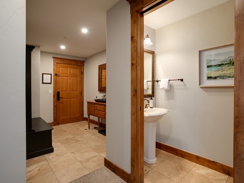 Bright and welcoming space with warm wood accents and clean lines. Your private bathroom features a pedestal sink and fresh towels, ready for you to settle in and relax after a long day.