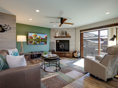 Settle into your cozy living room where natural light streams through the balcony doors, a warm fireplace awaits, and your favorite shows come alive on the flat-screen TV.