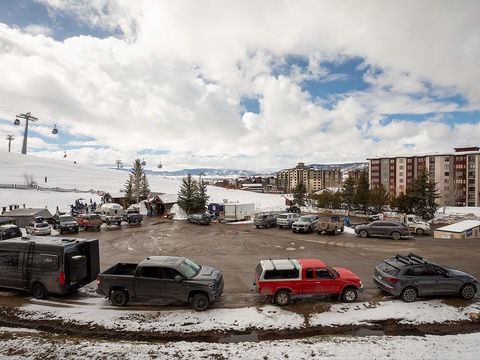 A mountain resort area with ski slopes and lodging buildings visible against a dramatic winter sky, offering convenient access to alpine recreation.