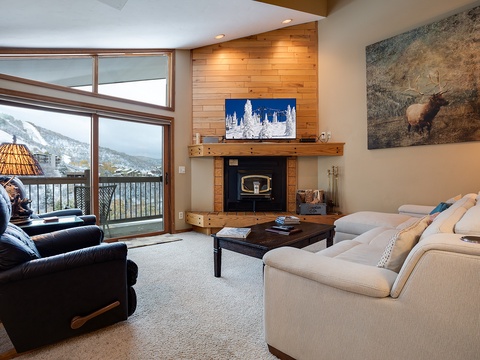 Sink into plush seating by the warm fireplace as you gaze out at stunning mountain views—your perfect retreat after a day of adventure.