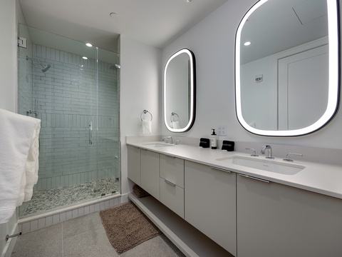 Pamper yourself in your spa-like bathroom with dual vanities, backlit mirrors, and a spacious walk-in shower with rain showerhead.