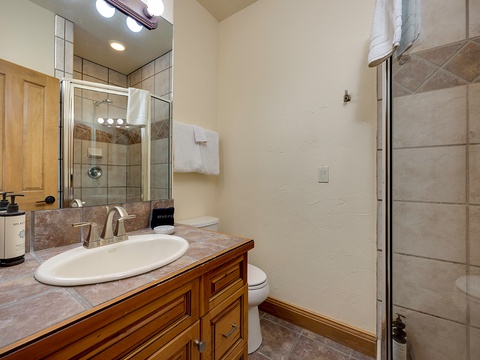 Step into your private retreat, featuring a walk-in shower with elegant tiled walls, fresh towels, and a stylish vanity to help you feel right at home.
