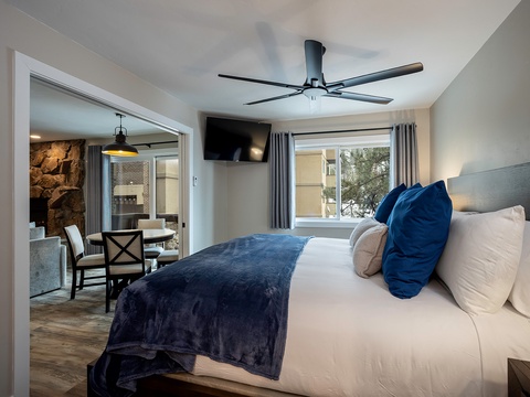 Sink into plush bedding beneath a modern ceiling fan. A wall-mounted TV and tranquil views set the stage for your perfect getaway retreat.