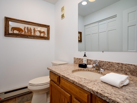 Freshen up in your private bathroom featuring granite counters, wood cabinetry, and thoughtful touches like fluffy towels—comfort and style blended perfectly for your stay.