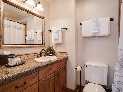 Step into your private bathroom retreat, where plush white towels and elegant granite countertops welcome you to unwind and refresh in style.