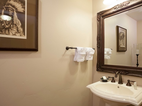 Your private bathroom features an elegant vanity with fresh towels waiting for you, plus thoughtful cultural artwork that adds character to your stay.