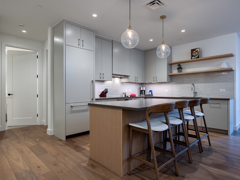 Your modern kitchen awaits with sleek cabinetry, stylish pendant lighting, and a breakfast bar perfect for morning coffee or casual dining together.