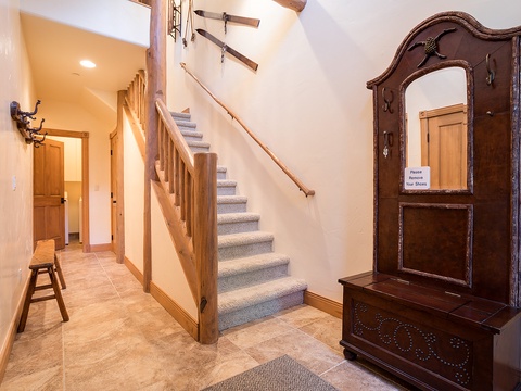 Step into a warm, welcoming entryway featuring rustic wood accents, a charming staircase, and antique furnishings that invite you to feel right at home from the moment you arrive.