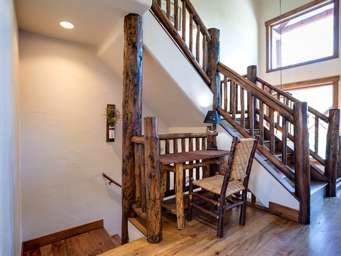 Natural wood railings and rustic charm welcome you in this bright, inviting entryway. Light filters through high windows, highlighting handcrafted details that make your mountain retreat feel authentically warm.