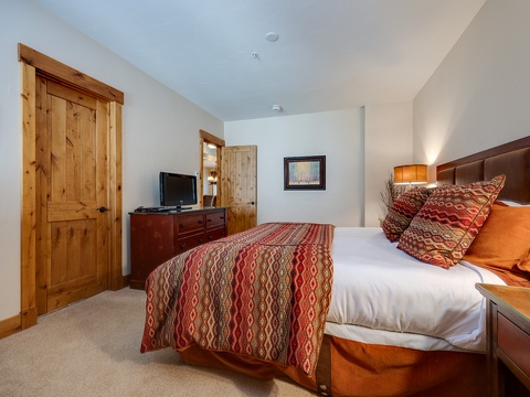 Settle into your cozy retreat with warm wood tones, vibrant patterned bedding, and thoughtful touches that make you feel instantly at home.