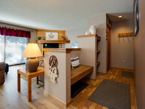 Step into a warm, thoughtfully designed entryway with natural wood accents, open shelving for your belongings, and soft lighting that welcomes you home after a day of adventure.