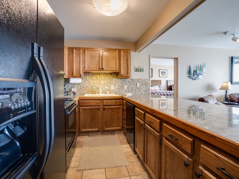 Your fully-equipped kitchen features granite counters, stainless appliances, and warm wood cabinetry—perfect for preparing meals after a day of mountain adventures.