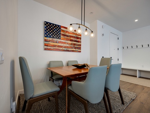 Gather around the stylish dining table for family meals or casual board games, with soft pendant lighting setting the perfect mood overhead.