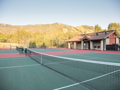 Multiple tennis courts backed by scenic mountain views and golden aspens, offering an ideal outdoor setting for friendly matches and active leisure.