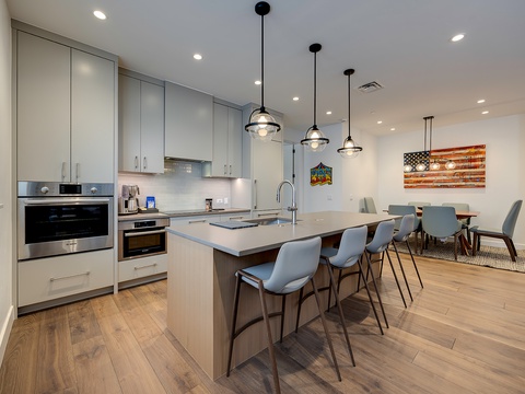 Your spacious gourmet kitchen awaits, complete with sleek stainless appliances, a generous island for gathering, and modern pendant lighting that sets the perfect mood for cooking and conversation.