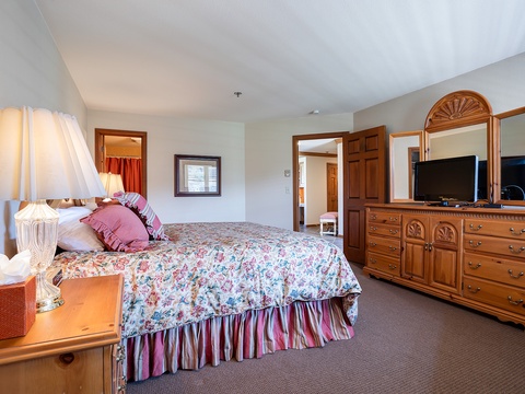 Sink into this cozy bedroom where soft linens and homey furnishings invite restful sleep, with plenty of drawer space and a TV for your entertainment.