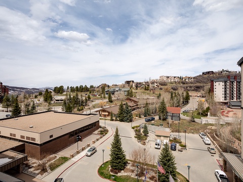 An elevated mountain resort area with multi-story buildings nestled among evergreens and hillside terrain, showcasing the property's location in a scenic, peaceful setting.