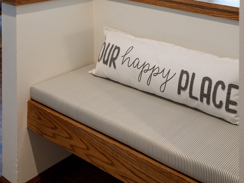 Settle into your cozy window seat nook with a cheerful pillow that reminds you this is your happy place—perfect for morning coffee or evening relaxation.
