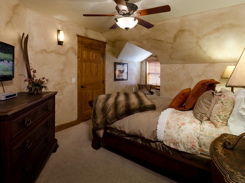 Sink into the plush bed with rustic charm, catch your favorite shows on the flat-screen, and drift off under the gentle hum of the ceiling fan in this cozy retreat.