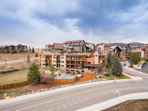Mountain resort community featuring the property with residential condominiums set against scenic hillside terrain and expansive skies.