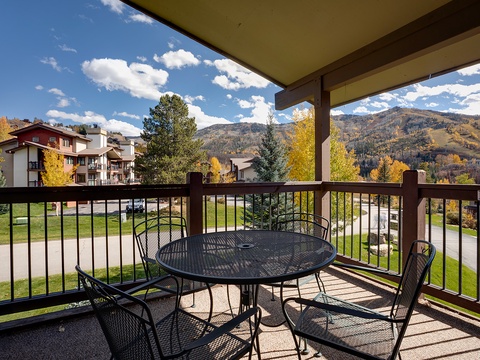 Covered balcony overlooks autumn-clad mountains and neighborhood streets, offering a peaceful spot to enjoy seasonal views and fresh mountain air.