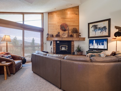 Settle into plush leather seating by your wood-burning fireplace and unwind with mountain views. Rustic charm meets cozy comfort in your thoughtfully designed living space.