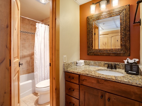 Step into your private bathroom, where warm tones and granite counters welcome you. Enjoy a refreshing shower or unwind after your mountain adventures in this tastefully designed space.