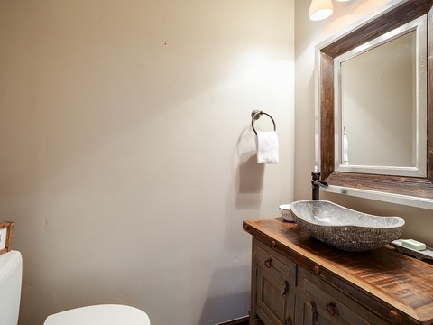 You'll love the rustic elegance of your private bathroom, featuring a stunning stone vessel sink atop handcrafted wood vanity, perfectly blending natural charm with modern comfort.