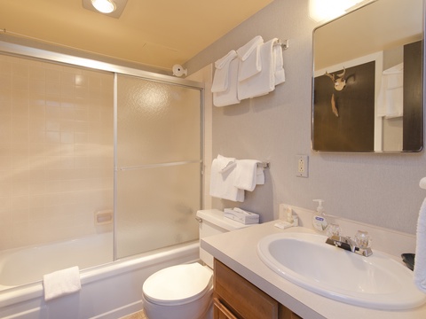 Your private bathroom offers everything you need to refresh and recharge—crisp white towels, a spacious vanity, and a soothing tub/shower combo ready for your relaxation.