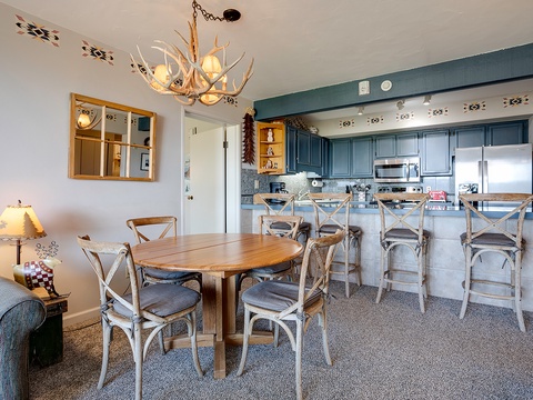 Picture yourself gathering around the rustic dining table or perched at the spacious breakfast bar, where mountain-lodge charm meets modern convenience in this welcoming open-concept space.