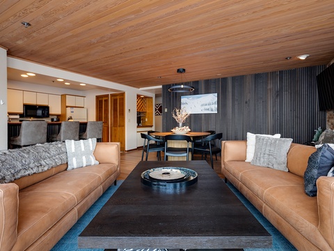 Relax into buttery leather sofas beneath warm wood ceilings, your perfect retreat for cozy evenings after mountain adventures or lakeside explorations.
