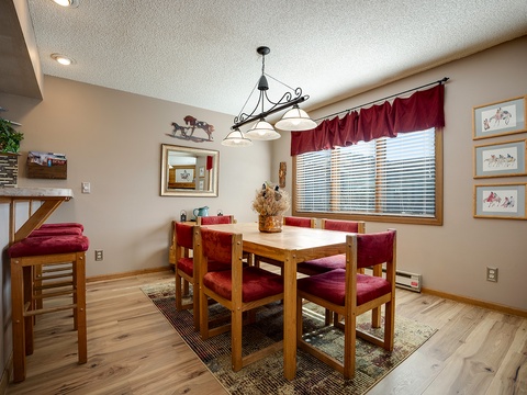 Gather around this warm dining space with rich wood tones and cozy red seating—perfect for sharing meals and making memories with your group.