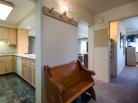 This bright hallway connects your fully equipped kitchen to cozy sleeping quarters, with charming wooden accents and a skylight inviting natural light into your vacation retreat.