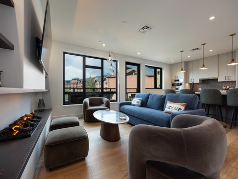 Unwind in this sleek living space, where modern comfort meets style. Plush seating, warm ambient lighting, and an open layout invite you to relax, while the connected kitchen makes entertaining effortless.