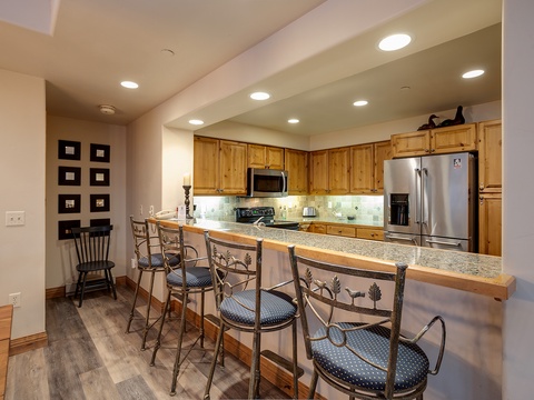 Pull up a stool at the spacious breakfast bar and enjoy morning coffee in this bright, fully equipped kitchen with modern appliances and plenty of counter space for preparing your favorite meals.