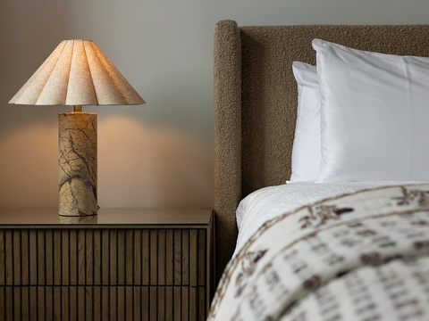 Sink into crisp linens and natural textures that invite your most restful sleep. A warm bedside lamp casts a gentle glow, setting the perfect mood for winding down.