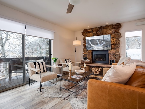 Sink into plush seating by the crackling fireplace as you gaze at snowy peaks through floor-to-ceiling windows—your perfect alpine retreat awaits.