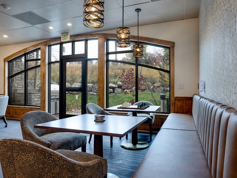 Relax in the communal lounge where modern style meets natural warmth. Sink into plush seating beneath sculptural lighting as garden views pour through arched windows, creating your perfect retreat.