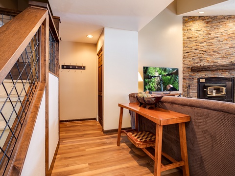 Settle into your cozy living space where warm wood tones meet a stunning stone fireplace. Unwind on the plush sofa, catch your favorite show, and feel right at home.
