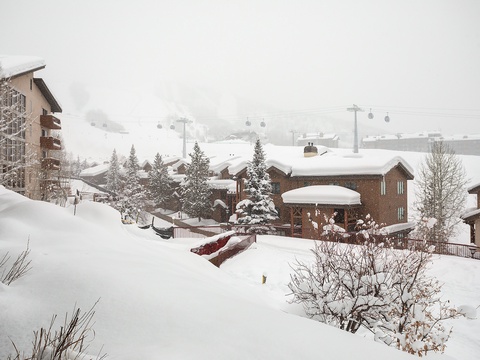 A snowy alpine village with ski lifts overhead, surrounded by snow-covered chalets and evergreens—perfect winter mountain scenery near the property.