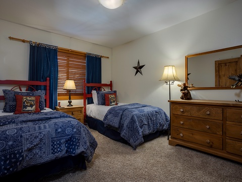 Two cozy twin beds with rich blue quilts and Western-themed accents await your arrival. Sink into comfort after a day exploring with matching lamps and a mirror-topped dresser at your side.