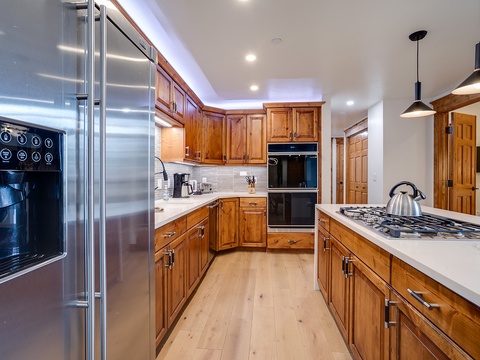 Your spacious kitchen features warm wood cabinetry, modern stainless-steel appliances, a gas range, and ample counter space—perfect for preparing family meals or morning coffee in comfort.