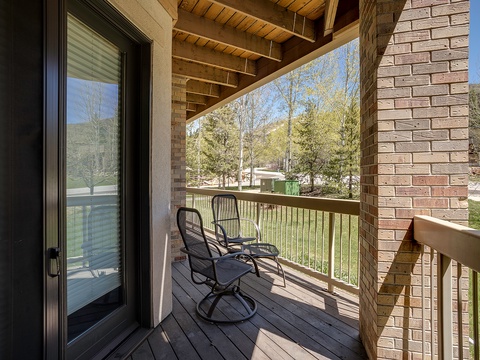 Step onto your private balcony and breathe in the crisp mountain air. Two swivel chairs await, perfectly positioned for morning coffee while you take in peaceful wooded views and surrounding greenery.