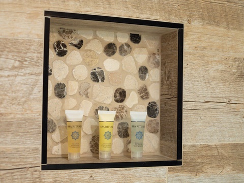 Spa Ritual amenities await in a decorative niche—your refreshing escape after a day exploring. Relaxation begins here.